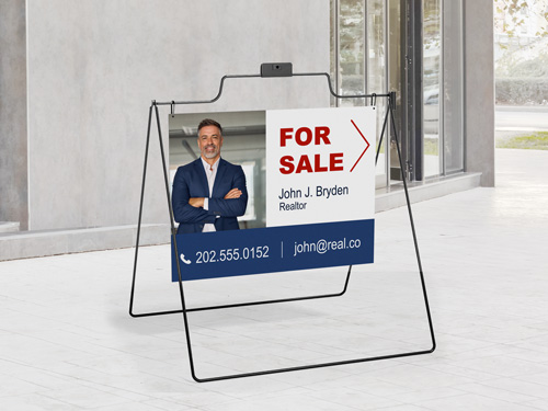 A-frame sign displaying agent's photo, name, and contact information for real estate services.