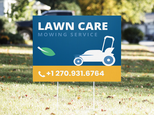 Yard sign on grass advertising a lawn care service, featuring bold green and white text, grass graphics, and company contact information