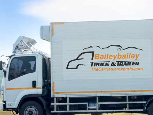Car dealership trailer decal with a company logo and contact information.