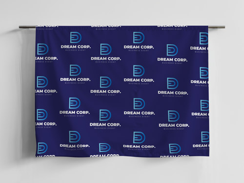 Blue fabric banner with repeating logos and text, used for branding at business events or trade shows.