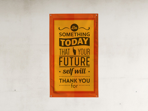 Orange fabric banner with decorative typography, mounted on a light-colored wall for motivational or decorative use