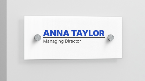 Plastic name label sign on the wall displaying Anna Taylor, Managing Director.