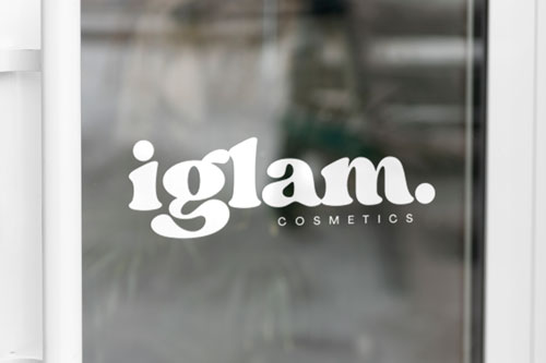 Opaque vinyl lettering on glass reading Iglam.Cosmetics.