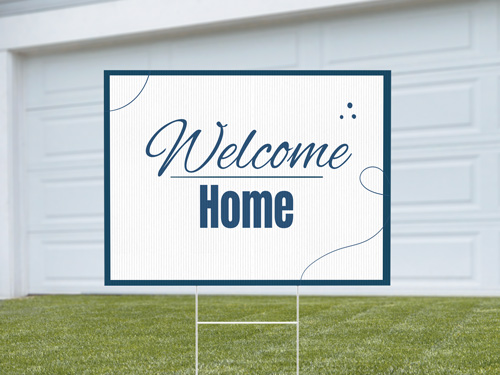 Decorative yard sign on a lawn featuring a cheerful “Welcome” message with graphics, used for personal or seasonal home decoration