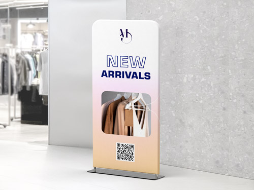 Retail tension fabric stand displaying New Arrivals with hanging clothes and a QR code.