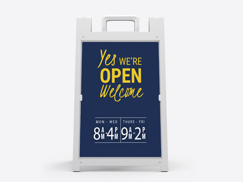 Blue and yellow open sign on sandwich board displaying business hours