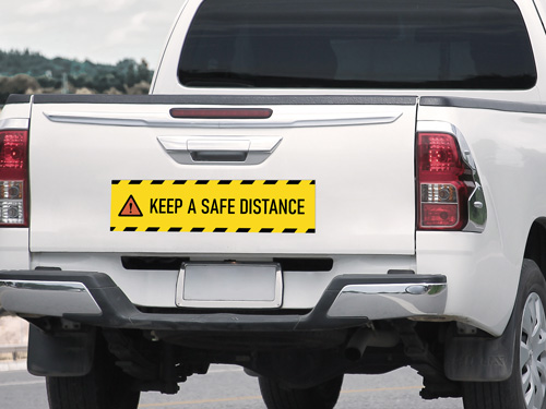 Yellow safety truck decal with Keep a Safe Distance message.