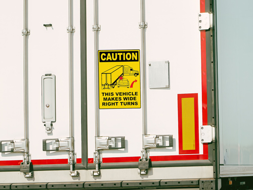Large trailer decal with yellow caution note warning This Vehicle Makes Wide Right Turns.