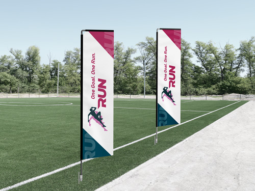 Rectangle flags at a sporting event displaying the message One Goal. One Run.