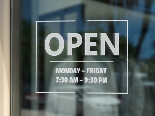 Store hours vinyl lettering reading ‘Open Monday–Friday’ with operating hours listed.