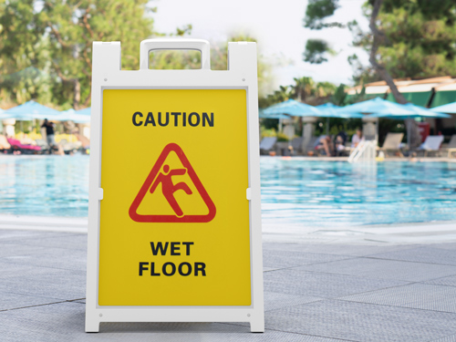 Street safety sandwich board displaying the message “Caution: Wet Floor.”
