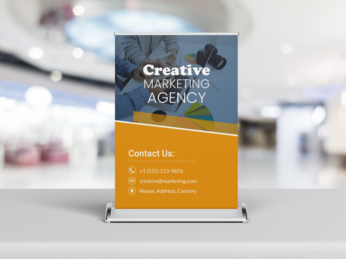 Tabletop retractable banner for a creative marketing agency with contact details displayed.