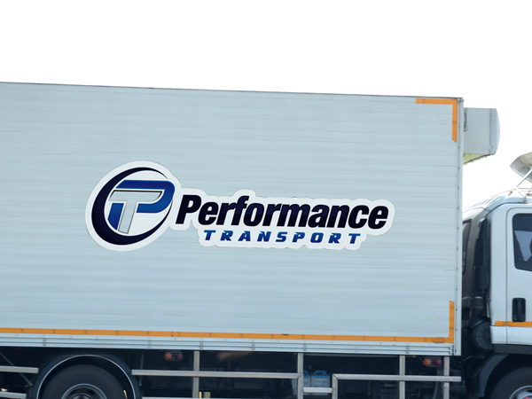 White trailer decal with Performance Transport company logo.