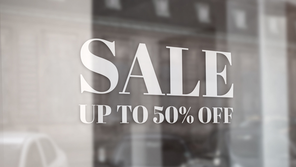 White vinyl window lettering reading ‘SALE UP TO 50% OFF’ on a storefront glass.