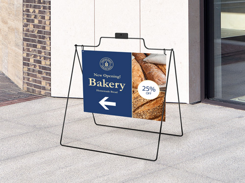 A-frame sidewalk sign advertising a bakery with bread images and directional arrow.