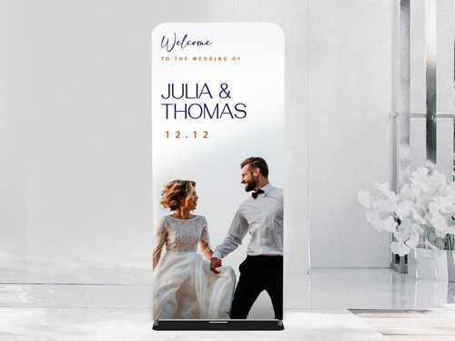 Elegant wedding-themed tension fabric stand with joyful bride, groom, and wedding date.