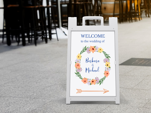 Wedding sandwich board with bride and groom's names and a welcoming message.